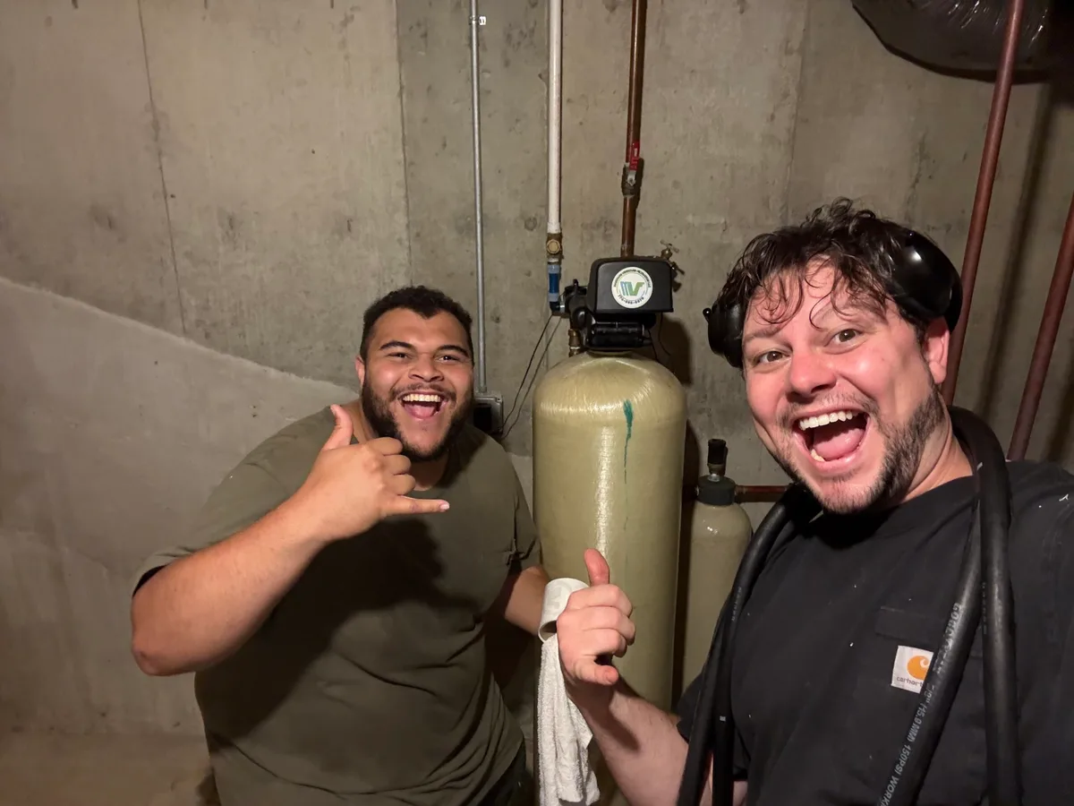 The owners of MV Filtration beside an installed water treatment system